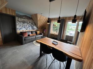a living room with a wooden table and chairs at Haus Bergquell App 6 in Willingen +9 photos