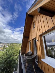 a wooden house with two chairs on a balcony at Haus Bergquell App 6 in Willingen