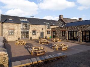 a patio with picnic tables in front of a building at 3 Bed in Ogmore-by-Sea 86494 in Southerndown
