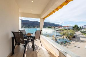 a balcony with a table and chairs and a view of the water at Apartments Holidays Roko in Grebaštica