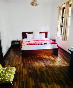a bedroom with a bed and a wooden floor at Raichak Ak22 Homestay in Raichak
