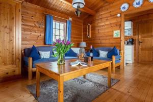 a living room with a table and blue couches at Blockhaus am Diemelsee in Sudeck