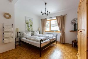 a bedroom with a bed with a chandelier and a window at Landhaus am Diemelsee in Diemelsee