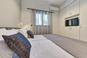 una camera con letto bianco e TV a parete di Villa Agaliou by "elite" a Ambelókipoi Altre 63 foto