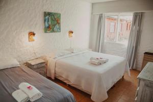 a bedroom with two beds and a window at Hostal Schilling in El Calafate