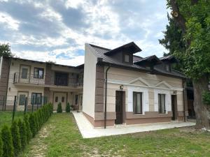 a large house with a tree in front of it at Casa Huber in Sighetu Marmaţiei