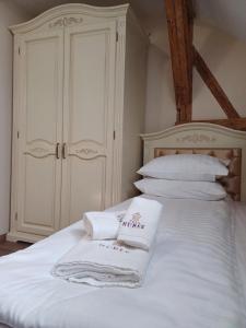 Casa Huber في سيغيتو مارماتيي: غرفة نوم مع منشفتين بيض على سرير