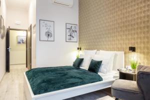 a bedroom with a bed with a green blanket at Extra Central New & Stylish Studio in Budapest