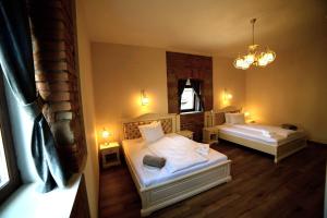 1 dormitorio con 2 camas y lámpara de araña en Casa Huber en Sighetu Marmaţiei