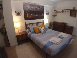 a bedroom with a bed with two towels on it at MERINDADES AMAZUL CORZO - Apartamento Turístico - Medina de Pomar in Medina de Pomar