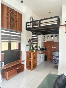 a living room with a loft bed and a kitchen at Burj Calapan in Calapan