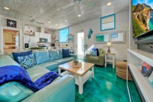 a living room with a blue couch and a table at Stella Maris Golf Cart Zone Near Beach Rooftop in Port Aransas