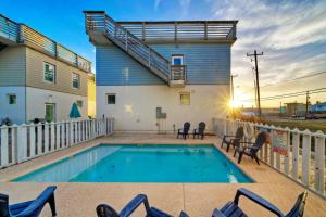 a swimming pool with chairs and a house at Stella Maris Golf Cart Zone Near Beach Rooftop in Port Aransas