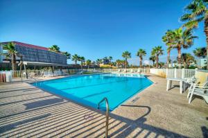 una piscina con sillas y palmeras en Rise N Beach by AvantStay Golf Cart Zone en Port Aransas