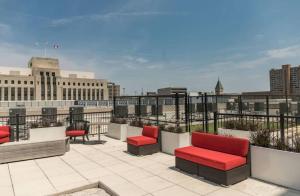 a rooftop patio with red chairs and a view of a city at Large 1 Bed Apt In The Heart Of Downtown in Des Moines
