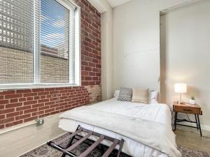 Bett in einem Zimmer mit Ziegelwand in der Unterkunft Stunning Downtown Studio With Rooftop Patio in Des Moines