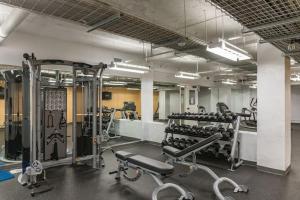 a gym with lots of tread machines and weights at Stunning Downtown Studio With Rooftop Patio in Des Moines