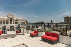 eine Terrasse mit roten Stühlen und Stadtblick in der Unterkunft Stunning Downtown Studio With Rooftop Patio in Des Moines