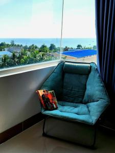 a blue couch sitting in front of a window at Mi Amor Luxury Island Apartment - 3 minutes to the beach in Phú Quốc