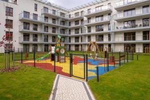 un parque infantil frente a un gran edificio de apartamentos en RentPlanet - Apartamenty Zakopiańskie II, en Zakopane