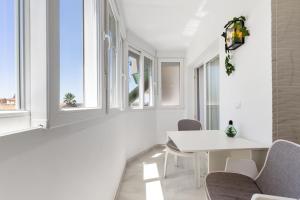 a white dining room with windows and a white table and chairs at Espanatour MENORCA in Dehesa de Campoamor