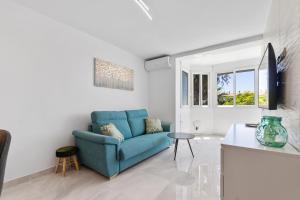 a living room with a blue couch and a tv at Espanatour MENORCA in Dehesa de Campoamor