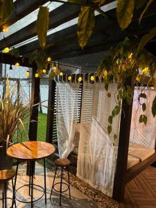 un patio con mesa, taburetes, mesa y ventana en Casa e espaço para festas - Espaço Maréas, en São Francisco do Sul