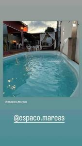 una gran piscina azul frente a una casa en Casa e espaço para festas - Espaço Maréas, en São Francisco do Sul