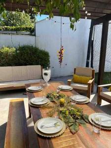 una mesa de madera con platos y platos. en Casa e espaço para festas - Espaço Maréas, en São Francisco do Sul