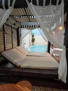 1 cama con dosel junto a la piscina en Casa e espaço para festas - Espaço Maréas, en São Francisco do Sul