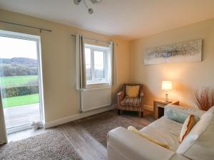 a living room with a couch and a large window at Country Cottage in Brecon