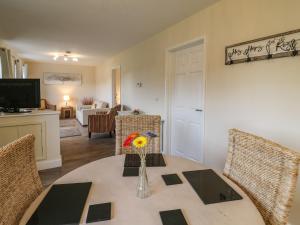 Country Cottage في بريكون: غرفة طعام مع طاولة مع إناء من الزهور