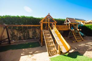 um parque infantil com um escorrega amarelo num quintal em Luxury Royal Blue Family Villa 8pers private pool em Hurghada