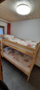 two bunk beds in a room with a ceiling at Ferienhaus Klotz das familienfreundliche Ferienhaus in Mittenwald