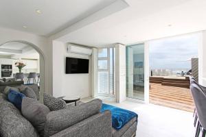 uma sala de estar com um sofá e uma varanda em Modern & Luxurious Seaside Apartment na Cidade do Cabo