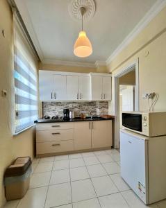 eine Küche mit einem weißen Kühlschrank und einer Mikrowelle in der Unterkunft MEK HOMEs 2 in Fethiye