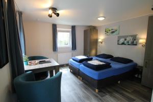 1 dormitorio con 1 cama, mesa y sillas en Chatel en Baarle-Nassau