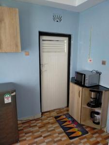 a kitchen with a door with a microwave on a counter at Greenstar Homes in Kisii