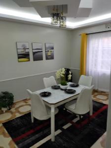 una sala da pranzo bianca con tavolo e sedie bianchi di Greenstar Homes a Kisii