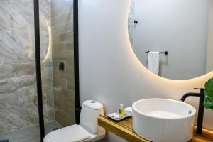 a bathroom with a sink and a toilet and a mirror at Hotel Amor de Mae in Santa Marta
