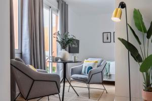 Una sala de estar con dos sillas y una mesa. en Suites Maestranza Santas Patronas - Penthouse with jacuzzi and parking, en Sevilla 2 fotos más