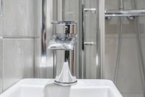 a drinking glass sitting on top of a sink at Close to City Centre Stylish and Cosy Home in Belfast