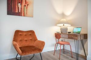 a chair sitting next to a desk with a laptop at Close to City Centre Stylish and Cosy Home in Belfast