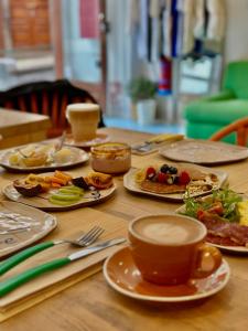 una mesa con platos de comida y una taza de café en Jaca Hostel Funchal, en Funchal