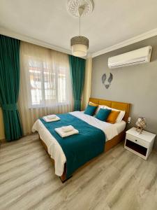 ein Schlafzimmer mit einem großen Bett mit blauen und orangefarbenen Kissen in der Unterkunft MEK HOMEs 2 in Fethiye