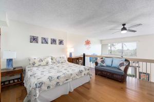a bedroom with a bed and a chair at Kona Alii 512 in Kailua-Kona