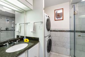 a bathroom with a sink and a washing machine at Kona Alii 512 in Kailua-Kona +30 photos