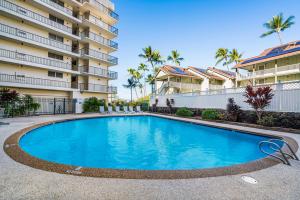 a swimming pool in front of a building at Kona Alii 512 in Kailua-Kona