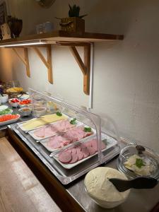 a counter top with meat and other food on it at Hotell Briggen i Åhus in Åhus