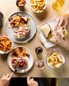 einen Tisch voller Teller mit Lebensmitteln mit Menschen, die Essen essen in der Unterkunft Leonardo Hotel East Midlands Airport in Castle Donington